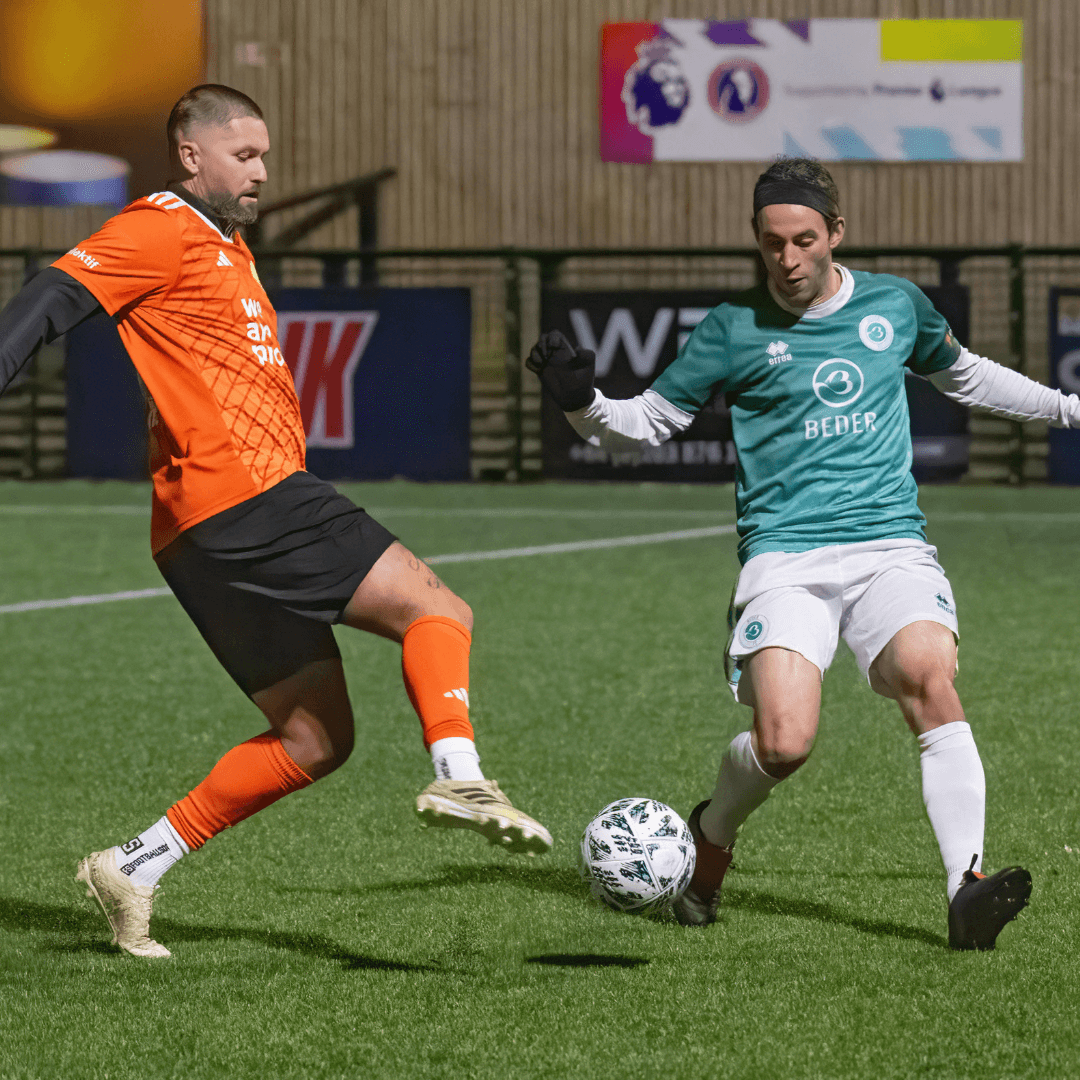 Intense action shot of two football players competing in a Legends match at Dorking Wanderers.